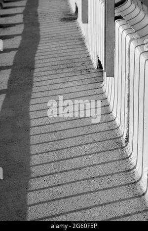 Der Schatten des Zauns während des Tages, Schwarz-Weiß-Foto. Stockfoto
