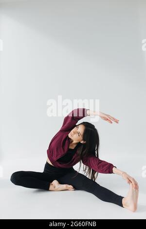 Sportliche armenische Frau, die Yoga in sitzender Seitenbeuge-Pose praktiziert Stockfoto