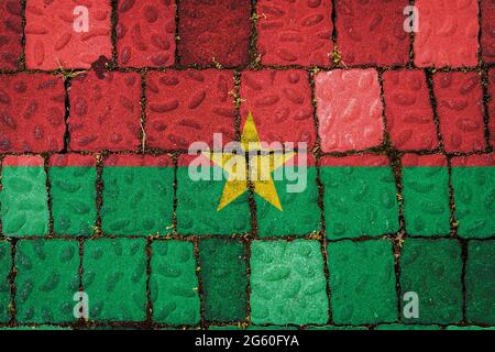 Nationalflagge von Burkino Faso auf Steinmauer Hintergrund. Flag Banner auf Stein Textur Hintergrund. Stockfoto