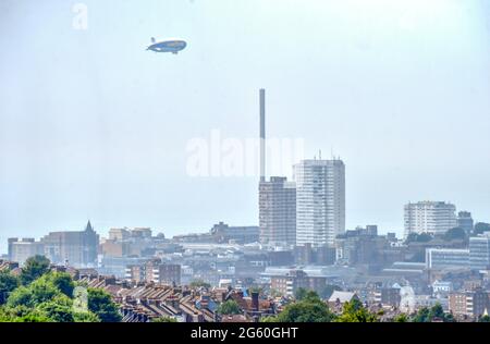 Brighton UK 1. Juli 2021 - die Goodyear Blimp Airship fliegt heute an einem heißen, aber nebligen Tag entlang der Südküste über die Skyline von Brighton : Credit Simon Dack / Alamy Live News Stockfoto