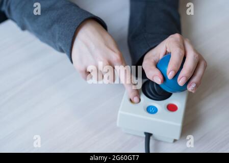 Frau mit zerebraler Lähmung arbeitet an einer spezialisierten Computermaus. Stockfoto
