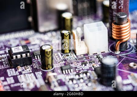 Nahaufnahme der Leiterplatten von alten PC-Desktop-Computern. Das Bild zeigt elektronische Bauteile, die auf farbige Keksbretter gelötet sind. Stockfoto
