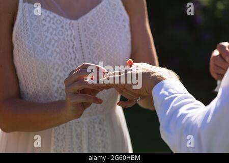 Kaukasische Braut und Bräutigam heiraten und Ring an Stockfoto