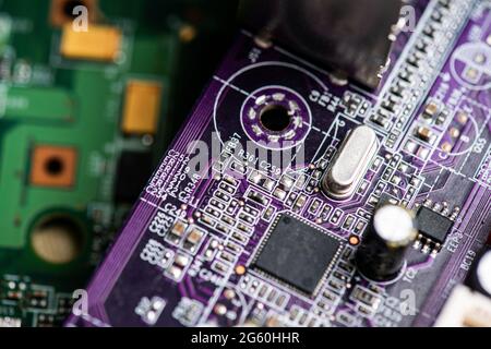 Nahaufnahme der Leiterplatten von alten PC-Desktop-Computern. Das Bild zeigt elektronische Bauteile, die auf farbige Keksbretter gelötet sind. Stockfoto