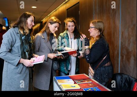 Drei Mädchen mit Büchern in den Händen stehen vor dem Buchhändler und erzählen den Kunden von verfügbaren Büchern. 2. November 2018. Kiew, Ukraine Stockfoto