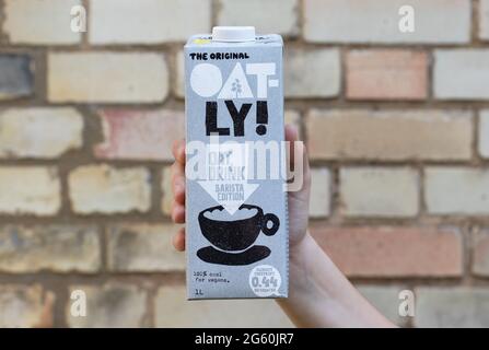 London / UK - 24. August 2019 - Hand hält einen Oatly Milchkarton. Oatly ist eine milchfreie vegane Milchalternative. Stockfoto