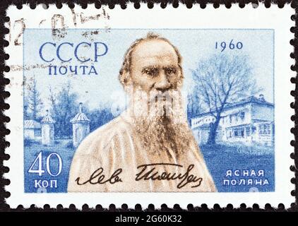 UdSSR - UM 1960: Eine in der UdSSR gedruckte Briefmarke zum 50. Todestag von Leo Tolstoi zeigt den Schriftsteller Leo Tolstoi und seinen Landsitz. Stockfoto