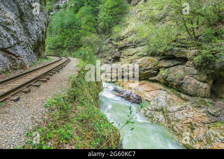 Schmalspurbahn und gebrochene Lokomotive in der tiefen engen Guam Schlucht. Westkaukasus. Russland. Stockfoto