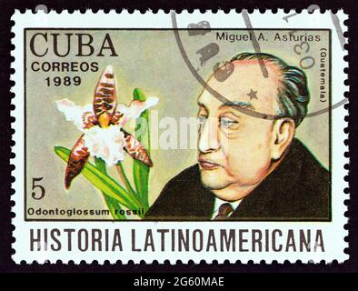 KUBA - UM 1989: Eine in Kuba gedruckte Briefmarke aus der Ausgabe 'Latin American History' zeigt Miguel Asturias und Odontoglossum rossii (Guatemala). Stockfoto