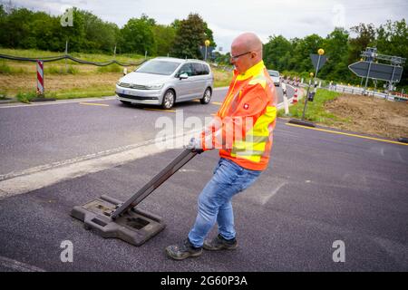 Wiesbaden, Deutschland. Juli 2021. Ein Verkehrssicherheitsmitarbeiter richtet die Ausfahrt in Richtung Wiesbaden ein. Die Autobahn GmbH West hat an der baufälligen Salzbachtal-Brücke eine sogenannte Umgehungsstraße eröffnet. Die Bundesstraße B263 kann nun wieder mit einer Spur in jede Richtung genutzt werden. Quelle: Andreas Arnold/dpa/Alamy Live News Stockfoto