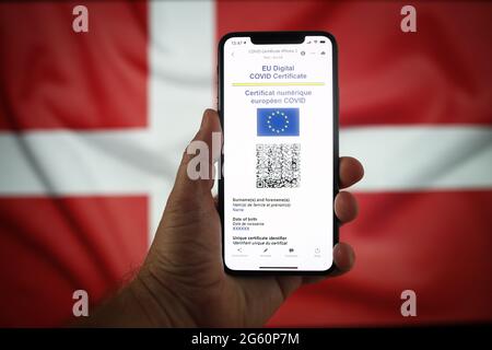 Warschau, Pl. Juli 2021. In dieser Abbildung am 1. Juli 2021 in Warschau, Polen, ist ein EU-COVID-Zertifikat auf einem mobilen Gerät mit einer dänischen Flagge im Hintergrund zu sehen. Das EU-COVID-Zertifikat, ein Dokument in digitaler oder analoger Form, das es vollständig geimpften Personen ermöglicht, in alle 27 EU-Mitgliedstaaten zu reisen, wird seit dem 1. Juli zur Verfügung gestellt. (Foto von Jaap Arriens/Sipa USA) Quelle: SIPA USA/Alamy Live News Stockfoto