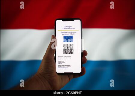 Warschau, Pl. Juli 2021. Auf einem mobilen Gerät ist am 1. Juli 2021 in Warschau, Polen, ein EU-COVID-Zertifikat mit der luxemburgischen Flagge im Hintergrund zu sehen. Das EU-COVID-Zertifikat, ein Dokument in digitaler oder analoger Form, das es vollständig geimpften Personen ermöglicht, in alle 27 EU-Mitgliedstaaten zu reisen, wird seit dem 1. Juli zur Verfügung gestellt. (Foto von Jaap Arriens/Sipa USA) Quelle: SIPA USA/Alamy Live News Stockfoto