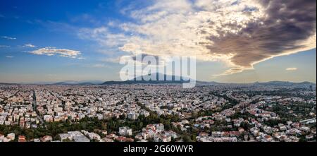 Sonnenuntergang über Athen, Griechenland. Luftdrohne Panoramablick von Penteli Mount. Letzte Sonnenstrahlen über dem Hintergrund der griechischen Hauptstadt. Reiseziel Athen, wo Sonne Stockfoto