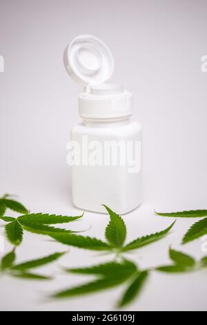 Weißes Glas und Cannabisblätter auf weißem Hintergrund Stockfoto