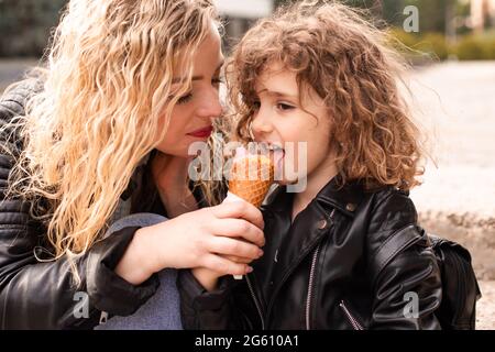 Die Mutter gibt ihrer Tochter Eis Stockfoto