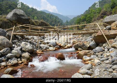 Dorfbewohner behelfsmäßige Bambusbrücke über den hochaktuellen himalaya-Fluss, die einzige Verbindung im abgelegenen Dorf, Todey, Kalimpong. Stockfoto