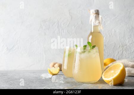Hausgemachtes Kombucha gesundes leckeres Getränk in Flasche und Gläsern mit Zitrone, Ingwer-Garnitur Minze. Organisches probiotisches Getränk, Kopierraum. Stockfoto