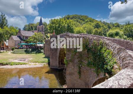 Frankreich, Aveyron, Dorf Belcastel, ehemalige Etappe auf der Straße nach Saint-Jacques-de-Compostelle, Dorf, das als eines der schönsten Dörfer Frankreichs bezeichnet wird, Steinbrücke aus dem 15. Jahrhundert über Aveyron mit der Kirche Sainte-Marie-Madeleine im Hintergrund, Kirche aus dem 15. Jahrhundert Stockfoto