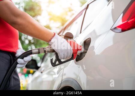 Die Nahaufnahme des Tankers mit Handschuhen betankt die Kunden und pumpt das Gas an der Tankstelle. Stockfoto