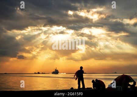 Sonnenuntergang Dämmerung Zeit und Sonnenbeleuchtung im Meer Ozean Blick ng Maynila Bucht am Manila baywalk auf Roxas Boulevard Straße für philippinische Menschen und ausländische Reisen Stockfoto