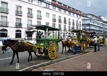 Philippinische Sit Ride Pferdekutschen und warten auf philippinische Menschen und ausländische Reisende nutzen Service Reise Besuch Tour Intramuros Platz im Mai Stockfoto