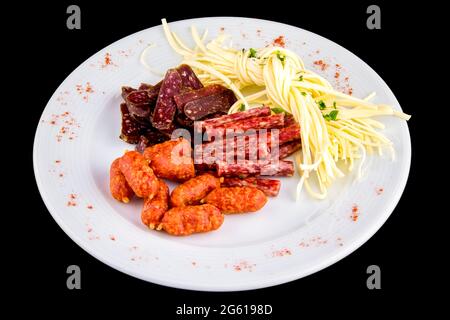 Biervorspeise: cecil-Käse, Picolini-Würste, Sujuk, Jorki. Teller mit leckeren geräucherten Würstchen auf schwarzem Hintergrund isoliert Stockfoto