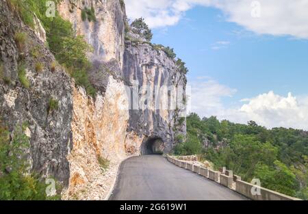 Bergstraße mit Tunnel im Berg zum Kloster Ostrog. Das Kloster liegt auf einer Höhe von ca. 900 m über dem Meeresspiegel. Montenegro Stockfoto