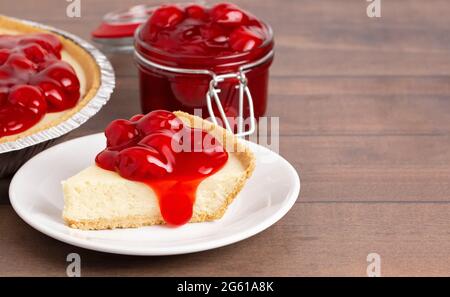 Ein klassischer einfacher, nicht backener Kirschkäsekuchen in einer Graham Cracker Kruste Stockfoto