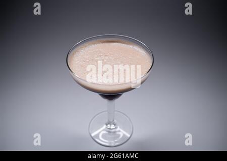 Luxuriöser Espresso martini-Cocktaildrink in elegantem Glas auf grauem Hintergrund Stockfoto