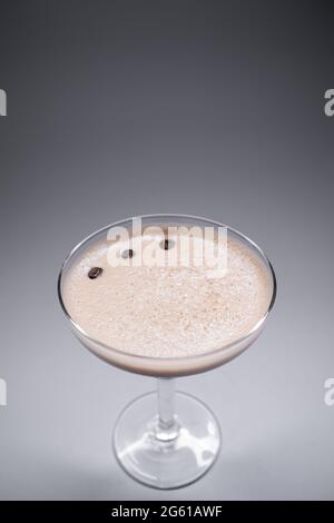 Luxuriöser Espresso martini-Cocktaildrink in elegantem Glas auf grauem Hintergrund Stockfoto