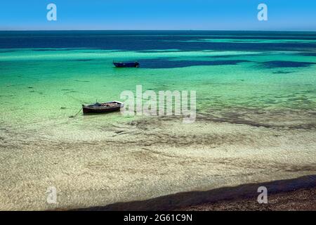 Herrliche Aussicht auf die Mittelmeerküste mit Birkenwasser, weißem Sandstrand und einem Fischerboot Stockfoto