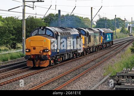 Drei der DRS, Direct Rail Services, Lokomotiven, 37423, 37038 und 57002, Fahren Sie auf der West Coast Main Line in Richtung Norden an der Balshaw Lane in Lancashire. Stockfoto