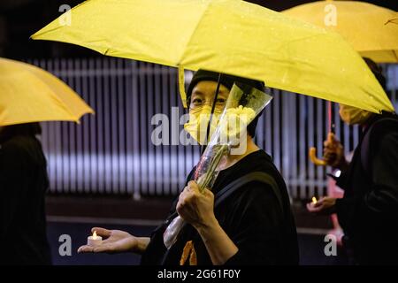 Tokio, Japan. Juli 2021. Ein Protestler mit Blumen und einem Regenschirm während der Demonstration am 1. Juli jährt sich die Gründung der KPCh (Kommunistische Partei Chinas) zum 100. Mal und der 24. Jahrestag der Übergabe Hongkongs an China. Anhänger der KPCh gingen auf die Straße, um zu feiern, während Demonstranten für Demokratie in Hongkong ebenfalls durch die Hauptstadt marschieren, um ihre politischen Standplätze auszudrücken. Kredit: SOPA Images Limited/Alamy Live Nachrichten Stockfoto