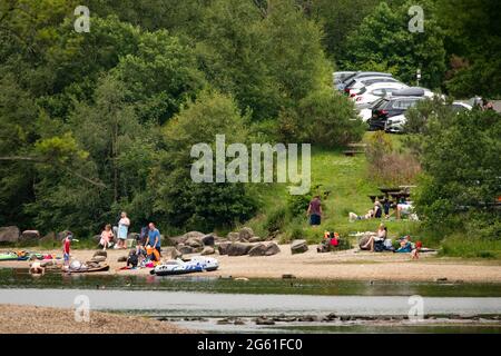 Loch Lubnaig, Loch Lomonnd und Trossachs National Park, Schottland, Großbritannien. Juli 2021. IM BILD: Menschen entspannen sich am Stein- und Kiesstrand von Loch Lubnaig. Die Leute nehmen ihre aufblasbaren Schlauchboote mit auf den loch und machen BBQs und Picknicks an der loch-Seite in der drückenden Hitze. Quelle: Colin Fisher/Alamy Live News Stockfoto