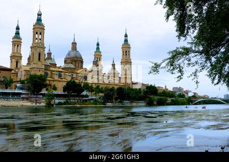 Blick auf die Kathedrale-Basilika unserer Lieben Frau von der Säule Zaragoza Aragon Spanien Frühlingssonne über den Fluss Ebro mit Kanufahrern Stockfoto