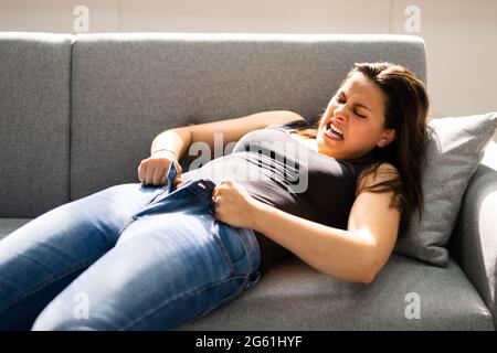 Frau Kämpft Mit Engen Jeans. Gewichtszunahme Stockfoto