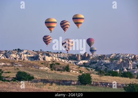 Heißluftballons am Himmel der Türkei fliegen über die Landschaft der Felsformation in Goreme, Wahrzeichen des Tourismus in Kappadokien Stockfoto