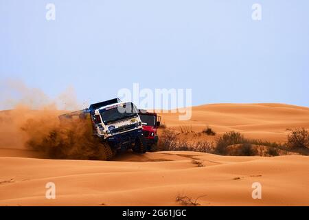 Die Rivalität zwischen Kamaz und Maz bei der Rallye. Der Sporttruck KAMAZ übersteht den schwierigen Teil der Strecke während des Rallye-Angriffs im Sand. DAS GOLD Stockfoto