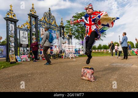 Kensington Palace, London, 1. Juli 2021. „Dancing for Diana“ - Diana Super Fan, John Loughrey, tanzt um eine Diana Handtasche vor den Toren des Kensington Palace, die er und seine königlichen Fans 8 Stunden lang mit Spruchbändern, Ballen und Ballonen dekorieren, um an den 60. Geburtstag von Prinzessin Diana zu erinnern. Prince's William und Harry enthüllten heute Nachmittag eine Statue zu ihren Ehren im versunkenen Garten. Kredit: amanda Rose/Alamy Live Nachrichten Stockfoto