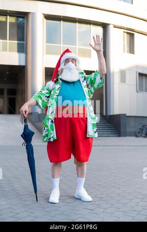 Porträt des weihnachtsmannes in Schutzmaske hawaiiihemd im Freien. Weihnachten im Coronavirus Stockfoto