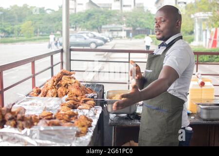 afrikanischer Mann, der Grillhähnchen verkauft Stockfoto