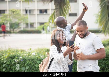 Junge afrikaner suchen in ein Telefon Stockfoto