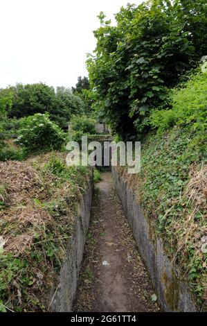 Versperrte Tür am Ende eines Grabens, die zu einem der verbleibenden Gebäude bei Brownstone Emergency Gun Battery in der Nähe von Kingswear Devon führt. Stockfoto