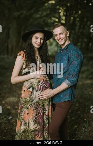 Nahaufnahme eines Porträts von einem glücklichen jungen lächelnden Paar, einem jungen Mann und seiner attraktiven Frau, die im Sommerwald vor der Kamera posiert Stockfoto