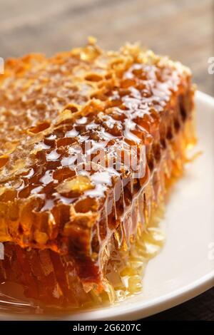 Nahaufnahme aus der Wabe. Frischer Honig vom Feld auf einem alten Holztisch. Stockfoto