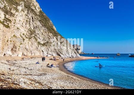 Menschen, die die Sonne am man O'war Beach in Dorset, Jurassic Coast, Großbritannien, genießen Stockfoto