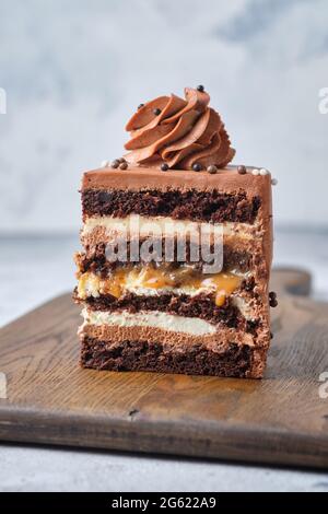 Cutaway Schokolade Biskuit. Kuchen mit zwei Arten von Creme: Frischkäse und Schokolade. Dessert gefüllt mit gesalzenem Karamell und Erdnüssen. Stockfoto