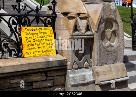 Ottawa, Ontario, Kanada - 1. Juli 2021: Ein Schild eines CANCEL Canda Day Protestes links vor dem West Block of Parliament Hill. Stockfoto