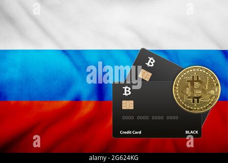 Zwei schwarze Kreditkarten und eine Bitcoin-Münze auf dem Hintergrund der russischen Flagge Stockfoto