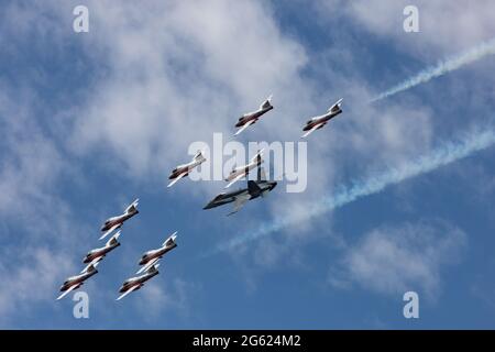 Ottawa, Ontario, Kanada - 1. Juli 2021: Die Snowbirds der kanadischen Streitkräfte fliegen in Formation mit einem CF-18-Demojet in einer Canada Day Demonstration. Stockfoto